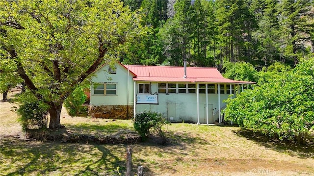38703 State Highway 96, Klamath River, CA 96086 - back of property featuring metal roof, a wooded view, and stucco siding