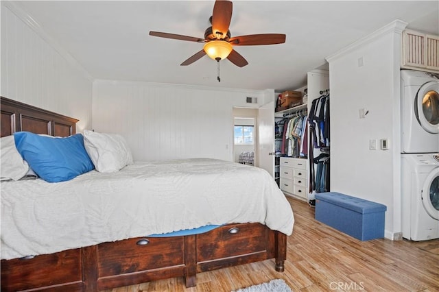 17882 Hallcroft Ln, Huntington Beach, CA 92647 - bedroom with stacked washer / drying machine, light wood-style flooring, crown molding, ceiling fan, and a closet