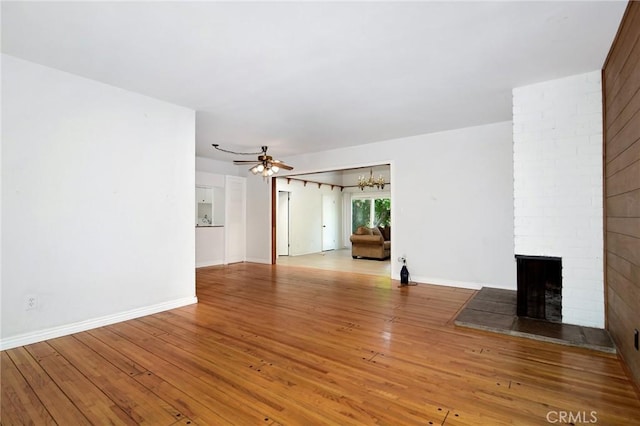 5655 Wish Ave, Encino, CA 91316 - unfurnished living room with a fireplace, light wood-style flooring, a ceiling fan, a chandelier, and baseboards