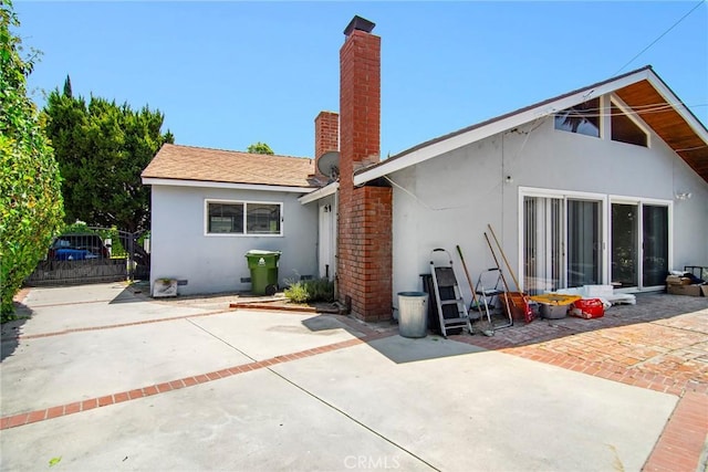 5655 Wish Ave, Encino, CA 91316 - rear view of property featuring stucco siding, a patio area, and a chimney