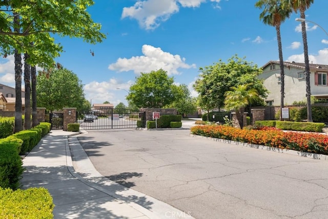 29463 Bouris Dr, Menifee, CA 92584 - view of asphalt road with street lights, sidewalks, a gate, a gated entry, and curbs