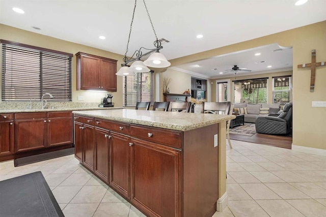 1327 Silver Hawk Way, Chula Vista, CA 91915 - kitchen featuring light tile patterned flooring, a kitchen island, ceiling fan, pendant lighting, and light stone counters