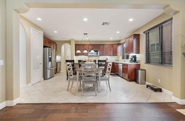 1327 Silver Hawk Way, Chula Vista, CA 91915 - kitchen with appliances with stainless steel finishes, arched walkways, light countertops, recessed lighting, and light wood-style floors