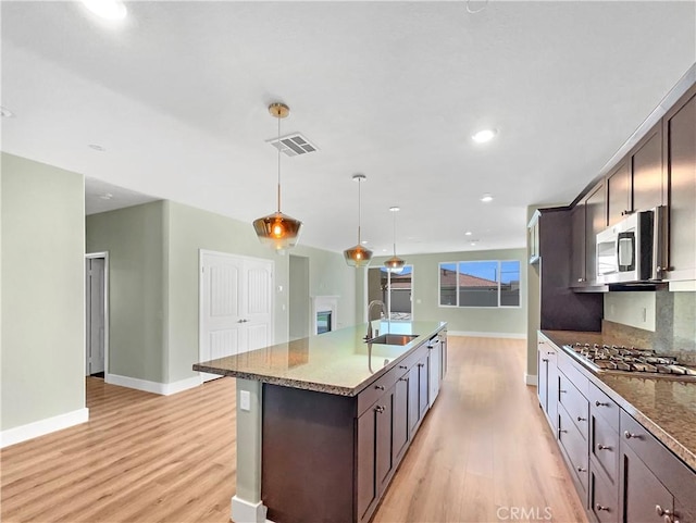 27117 Great Plains Ct, Menifee, CA 92585 - kitchen featuring a sink, appliances with stainless steel finishes, light wood-style floors, dark brown cabinets, and recessed lighting