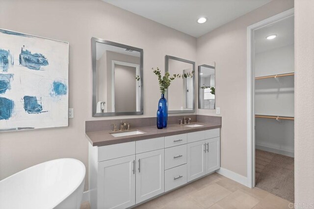 13403 Hudson Ln, San Diego, CA 92130 - full bath with double vanity, a soaking tub, a spacious closet, recessed lighting, and tile patterned floors