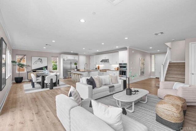 13403 Hudson Ln, San Diego, CA 92130 - living room with ornamental molding, recessed lighting, light wood-type flooring, and stairway