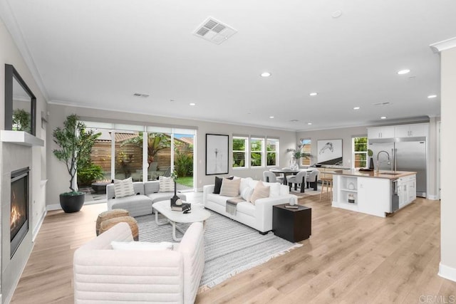 13403 Hudson Ln, San Diego, CA 92130 - living area featuring ornamental molding, a glass covered fireplace, recessed lighting, and light wood-style floors