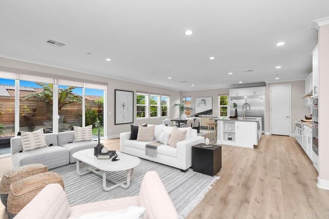 13403 Hudson Ln, San Diego, CA 92130 - living room with recessed lighting, ornamental molding, and light wood-type flooring