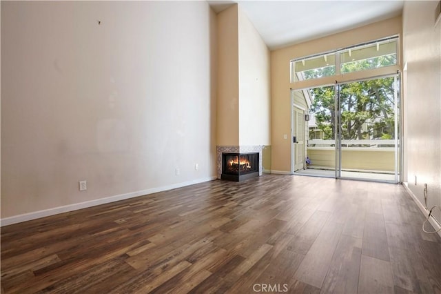 3690 S Bear St Unit 5, Santa Ana, CA 92704 - unfurnished living room with dark wood-style flooring, a multi sided fireplace, and baseboards