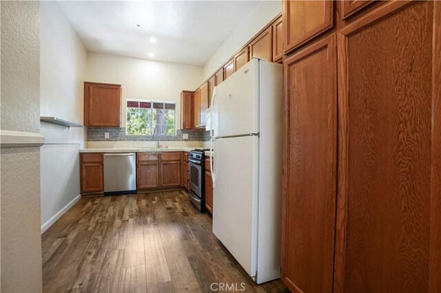 3690 S Bear St Unit 5, Santa Ana, CA 92704 - kitchen with appliances with stainless steel finishes, a sink, brown cabinets, dark wood finished floors, and backsplash