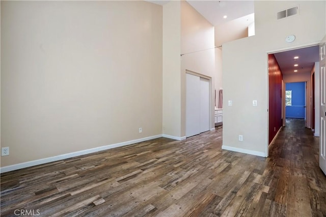 3690 S Bear St Unit 5, Santa Ana, CA 92704 - empty room with dark wood-type flooring, baseboards, a towering ceiling, and recessed lighting