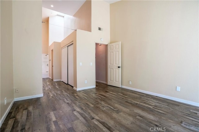 3690 S Bear St Unit 5, Santa Ana, CA 92704 - unfurnished room with dark wood finished floors, a towering ceiling, and baseboards