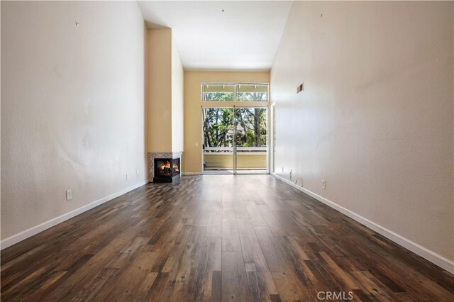 3690 S Bear St Unit 5, Santa Ana, CA 92704 - unfurnished living room with dark wood-type flooring, baseboards, and a multi sided fireplace