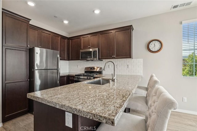 24117 Dolcetto Ave Unit 104, Murrieta, CA 92562 - kitchen with appliances with stainless steel finishes, a sink, a peninsula, baseboards, and dark brown cabinetry
