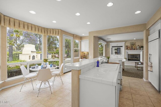 741 Sterling Hills Dr, Camarillo, CA 93010 - kitchen featuring tile counters, a sink, light tile patterned floors, recessed lighting, and white cabinetry