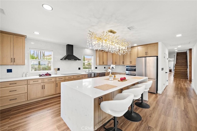 22621 Ridge Line Rd, Diamond Bar, CA 91765 - kitchen featuring wall chimney range hood, appliances with stainless steel finishes, a sink, a breakfast bar, and a center island