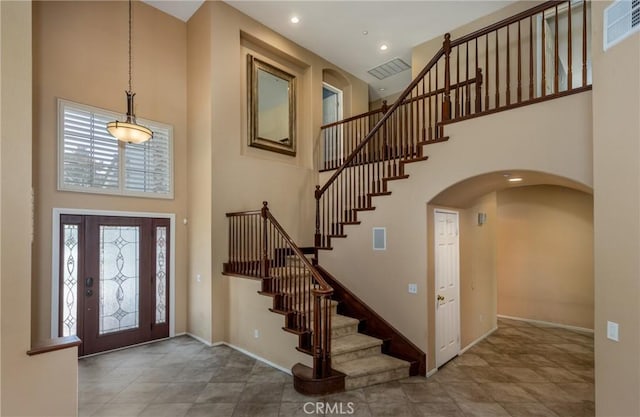 1550 Jameson Ct, Riverside, CA 92507 - foyer entrance with a high ceiling, healthy amount of natural light, stairway, baseboards, and arched walkways