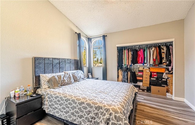 14819 Downey Ave Unit 121, Paramount, CA 90723 - bedroom featuring a textured ceiling, wood finished floors, a closet, lofted ceiling, and baseboards