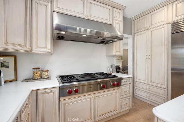 21035 Timber Ridge Rd, Yorba Linda, CA 92886 - kitchen with under cabinet range hood, cream cabinetry, appliances with stainless steel finishes, and light countertops