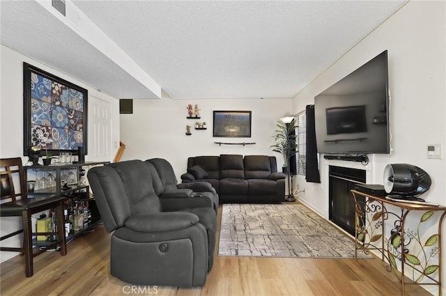 25520 Dodge Ave Unit A, Harbor City, CA 90710 - living room featuring wood finished floors, a fireplace, and a textured ceiling
