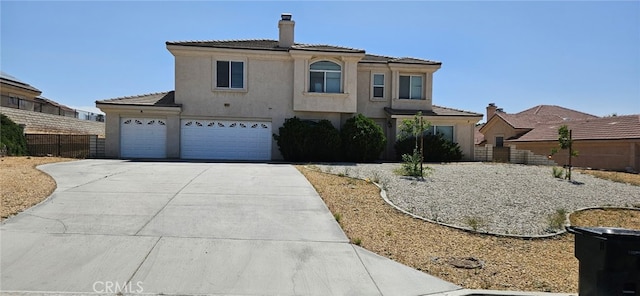 16245 Ridge View Dr, Apple Valley, CA 92307 - mediterranean / spanish-style home with concrete driveway, a chimney, stucco siding, a garage, and a tiled roof