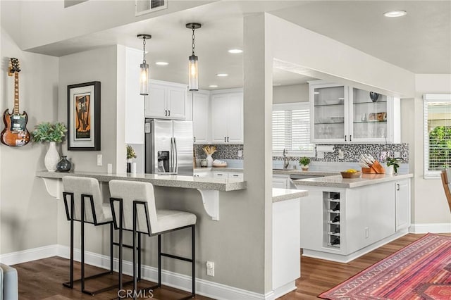 6 Stansbury Ct, Chico, CA 95928 - kitchen featuring stainless steel fridge, a peninsula, dark wood finished floors, plenty of natural light, and recessed lighting