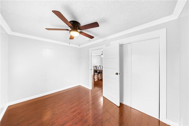 157 E 70th St, Los Angeles, CA 90003 - unfurnished bedroom with ornamental molding, dark wood finished floors, a closet, baseboards, and a textured ceiling