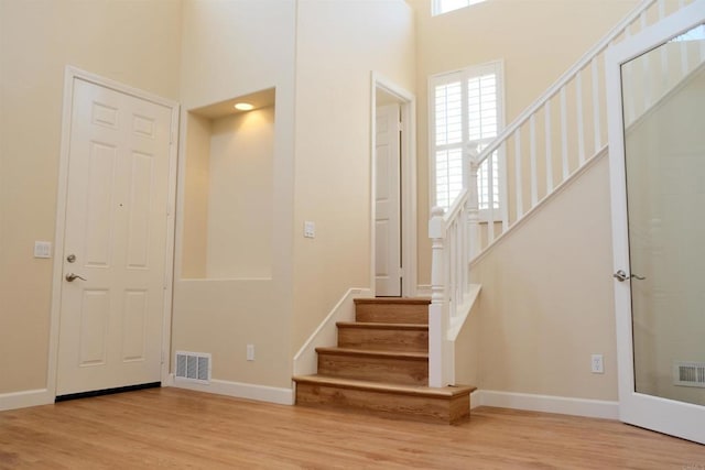 7040 Whitewater St, Carlsbad, CA 92011 - foyer with stairway, wood finished floors, and a towering ceiling