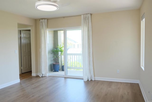 7040 Whitewater St, Carlsbad, CA 92011 - empty room featuring healthy amount of natural light and wood finished floors