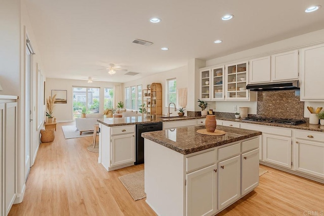 7040 Whitewater St, Carlsbad, CA 92011 - kitchen featuring black dishwasher, a peninsula, stainless steel gas stovetop, a kitchen island, and white cabinets