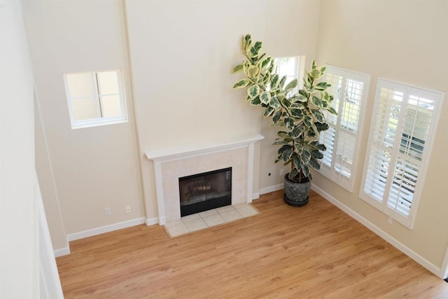 7040 Whitewater St, Carlsbad, CA 92011 - living area featuring wood finished floors, a tile fireplace, and a towering ceiling