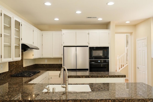 7040 Whitewater St, Carlsbad, CA 92011 - kitchen with black appliances, under cabinet range hood, glass insert cabinets, a peninsula, and recessed lighting