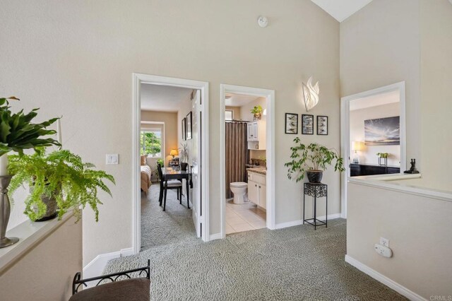 6839 Caminito Sueno, Carlsbad, CA 92009 - hallway featuring light colored carpet, baseboards, and a towering ceiling