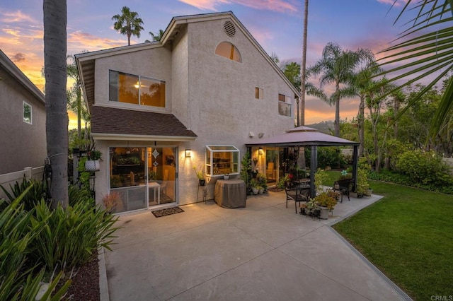 6839 Caminito Sueno, Carlsbad, CA 92009 - back of property at dusk featuring a gazebo, stucco siding, a yard, and a patio