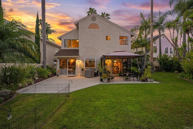 6839 Caminito Sueno, Carlsbad, CA 92009 - back of house at dusk featuring a patio area, a gazebo, stucco siding, and a fenced backyard