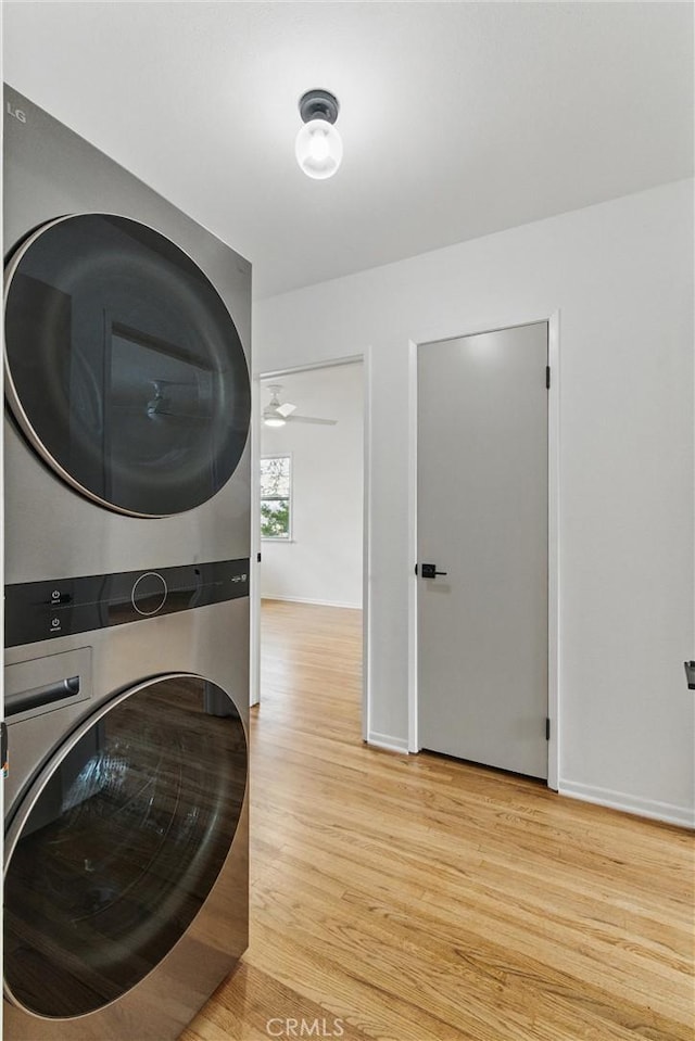 5802 Bowcroft St Unit 4, Los Angeles, CA 90016 - washroom with stacked washer / dryer, wood finished floors, and baseboards