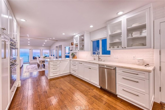 1155 Katella St, Laguna Beach, CA 92651 - kitchen featuring stainless steel dishwasher, a sink, white cabinets, a peninsula, and glass insert cabinets