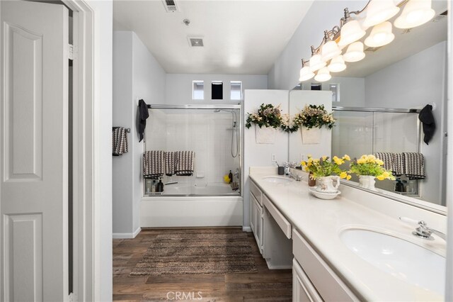 12909 Ternberry Ct, Tustin, CA 92782 - bathroom featuring double vanity, wood finished floors, and combined bath / shower with glass door