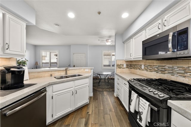 12909 Ternberry Ct, Tustin, CA 92782 - kitchen featuring stainless steel appliances, a sink, a peninsula, white cabinets, and dark wood-style floors