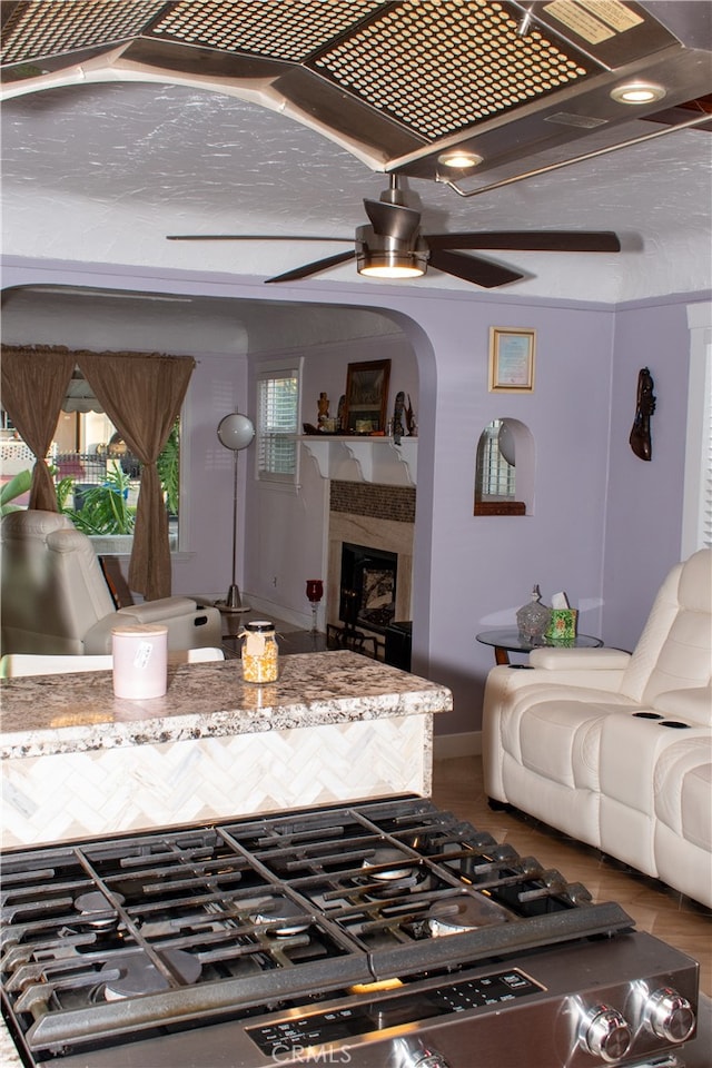 1831 W 68th St, Los Angeles, CA 90047 - living room featuring ceiling fan, a premium fireplace, and arched walkways