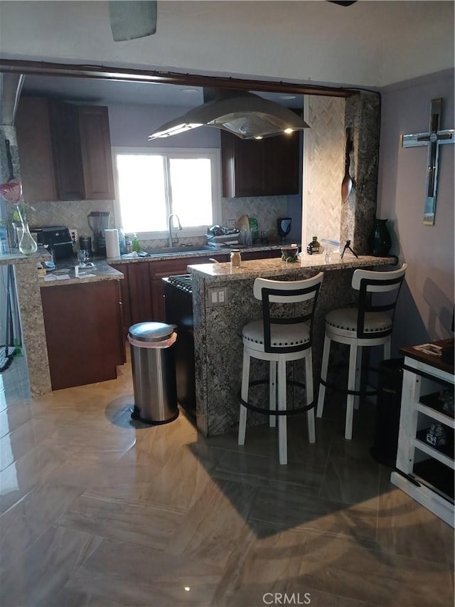 1831 W 68th St, Los Angeles, CA 90047 - kitchen featuring backsplash, a sink, a breakfast bar, and stone counters