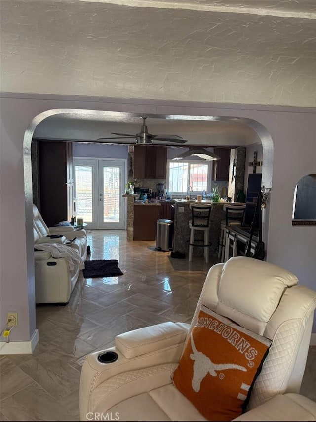 1831 W 68th St, Los Angeles, CA 90047 - living room with arched walkways, french doors, ceiling fan, and baseboards