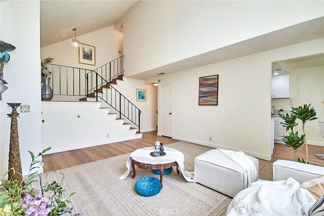 4838 Elrovia Ave Unit E, El Monte, CA 91732 - living area with light wood-style flooring, high vaulted ceiling, stairs, and baseboards