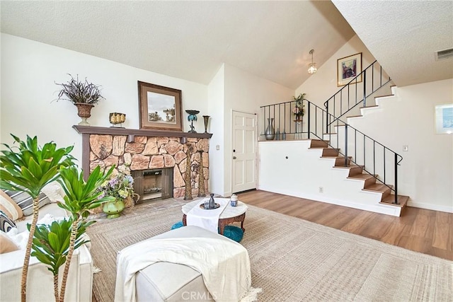 4838 Elrovia Ave Unit E, El Monte, CA 91732 - living room with wood finished floors, stairway, a fireplace, a textured ceiling, and baseboards