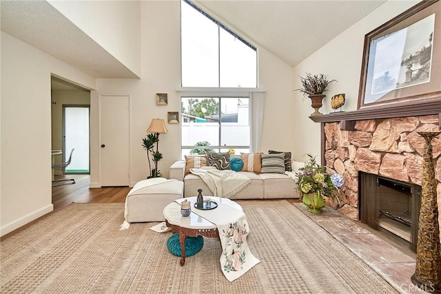 4838 Elrovia Ave Unit E, El Monte, CA 91732 - living area featuring a fireplace, wood finished floors, high vaulted ceiling, and baseboards