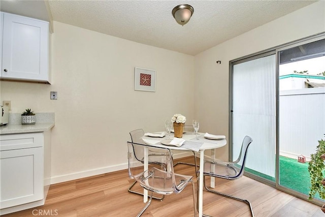 4838 Elrovia Ave Unit E, El Monte, CA 91732 - dining area with light wood-style floors, baseboards, and a textured ceiling