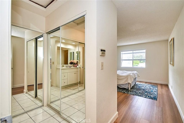 4838 Elrovia Ave Unit E, El Monte, CA 91732 - hallway featuring a textured ceiling, light wood-style floors, and baseboards