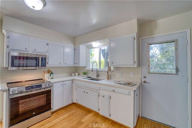 1770 Alrita St, San Luis Obispo, CA 93401 - kitchen with appliances with stainless steel finishes, light countertops, white cabinetry, and light wood finished floors