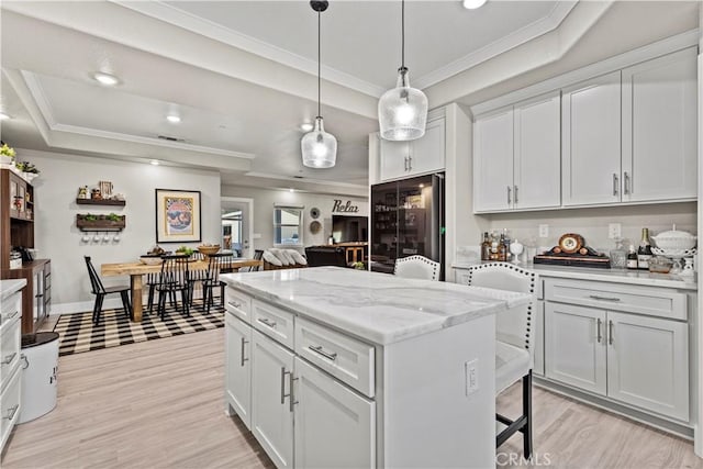 678 Colusa, Gridley, CA 95948 - kitchen with a raised ceiling, ornamental molding, light wood-type flooring, a center island, and decorative light fixtures
