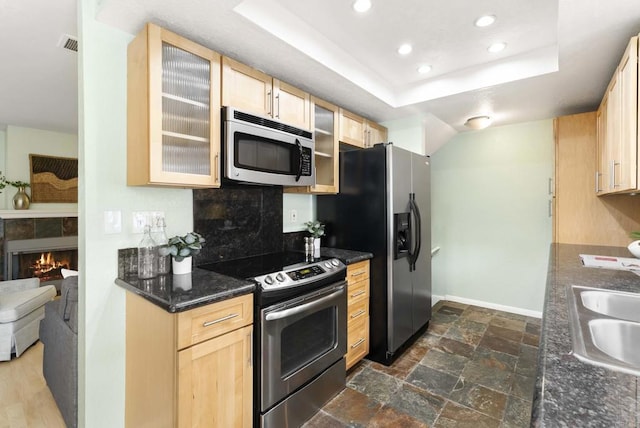 4535 Chateau Dr, San Diego, CA 92117 - kitchen featuring stainless steel appliances, light brown cabinetry, a sink, decorative backsplash, and glass insert cabinets